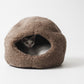 Cat peeking out from a brown cave-shaped pet bed on a white background  | Natural, non‑toxic pet nest for cats and small dogs | Cozy, handmade pet furniture

