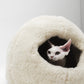 White cat peeking out from a fluffy white pet bed on a light gray  background | Natural, non‑toxic pet nest for cats and small dogs | Cozy, handmade pet furniture, natural wool and sheepskin

