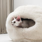 Cat peeking out from a white natural pet bed against a neutral background | Natural, non‑toxic pet nest for cats and small dogs | Cozy, handmade pet furniture, natural wool and sheepskin

