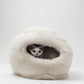 Cat peeking out from a fluffy white pet bed on a light gray background | Natural, non‑toxic pet nest for cats and small dogs | Cozy, handmade pet furniture, natural wool and sheepskin

